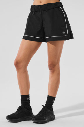 Motivate Track Short featuring contrast piping, zippered pockets, and a sporty chic design for performance and style.