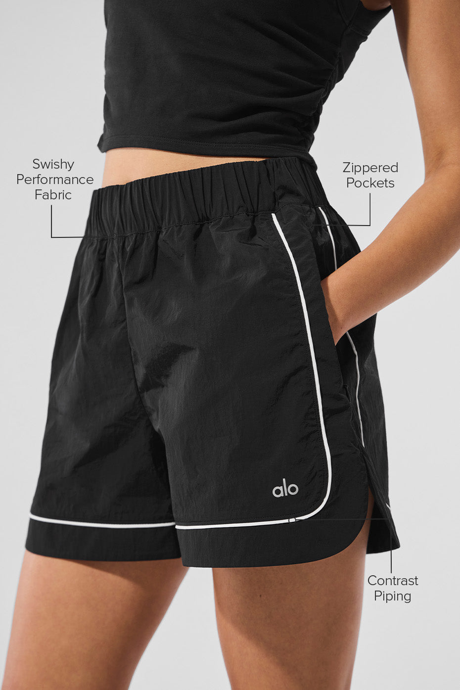 Motivate Track Short with swishy performance fabric, contrast piping, and zippered pockets, perfect for sporty chic outfits.