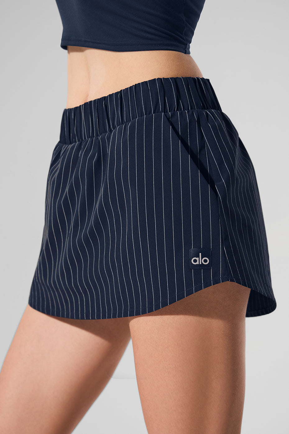 Pinstripe Daylight Mini Skirt featuring built-in shorts and lightweight structure for sunny days and chic evenings.