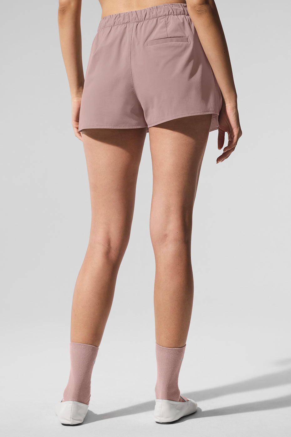 Back view of Flip It Mini Skort in soft pink with elastic waistband and shorts under skirt design.