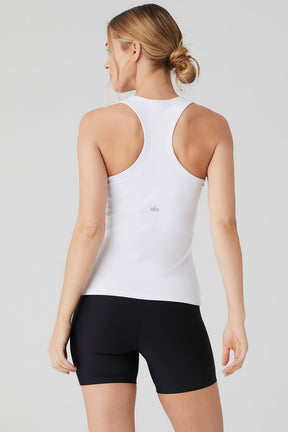 Model wearing the Ribbed Aspire Full Length Tank in white with racerback style and paired with black shorts.