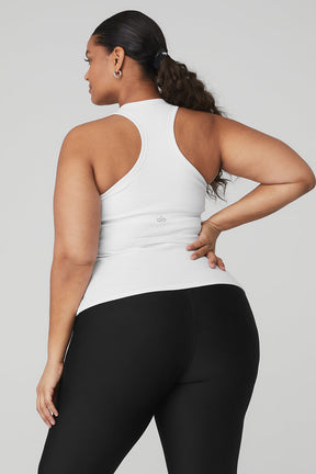 Back view of a woman wearing a white Ribbed Aspire Full Length Tank with a racerback and black leggings.