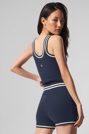 Model wearing a navy Tennis Club Sweater Knit Tank with contrast stripes, showcasing a fitted and slightly cropped design.